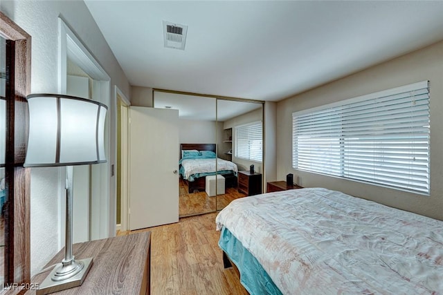 bedroom featuring wood finished floors and visible vents