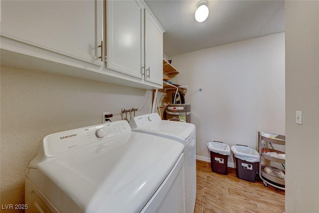 laundry area featuring cabinet space, light wood-style flooring, baseboards, and independent washer and dryer