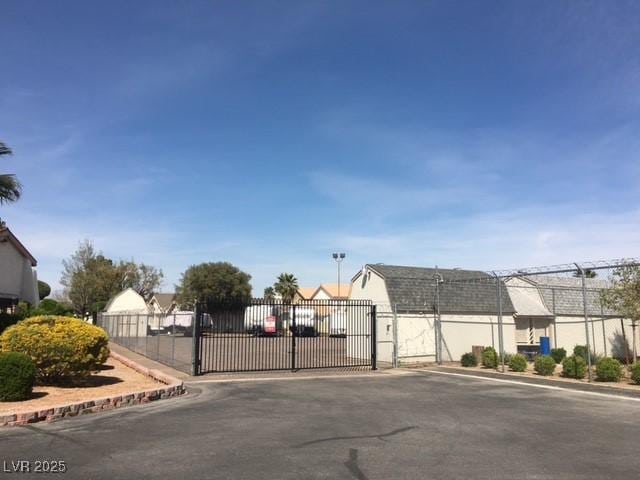 view of road with a gate, a gated entry, and curbs