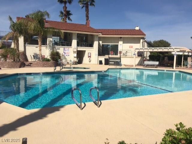 community pool featuring fence, a pergola, and a patio