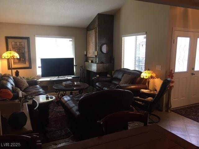 living room featuring lofted ceiling and tile patterned flooring