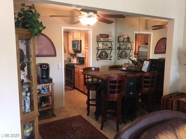 bar featuring a ceiling fan, black range, and stainless steel microwave