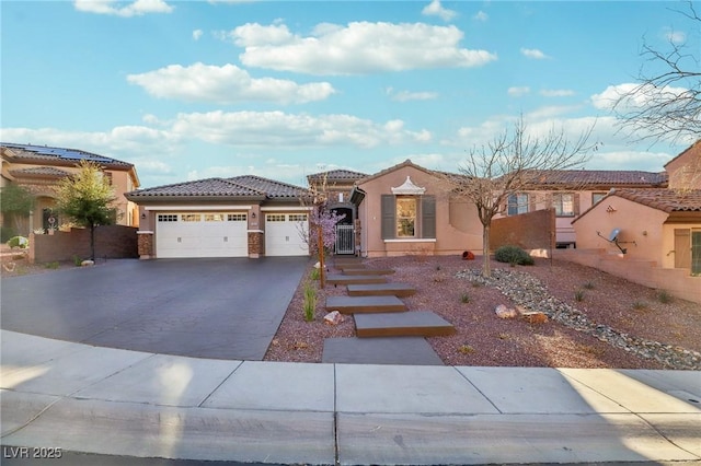 mediterranean / spanish house with an attached garage, stucco siding, driveway, and a tiled roof