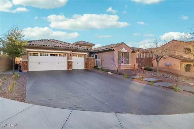 view of front of house with driveway, a tiled roof, a garage, and stucco siding