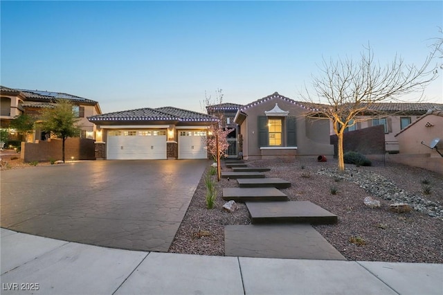 view of front of house with an attached garage, stucco siding, concrete driveway, and a tiled roof