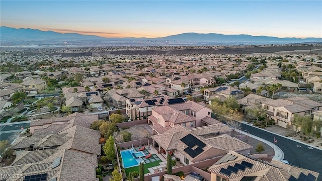 aerial view at dusk featuring a mountain view and a residential view