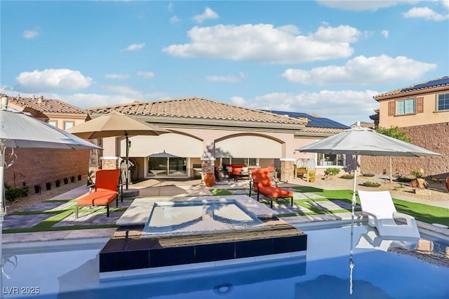 back of property with a tile roof, a patio, and stucco siding