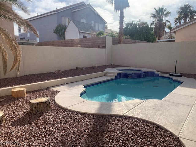 view of swimming pool with an in ground hot tub and a fenced backyard