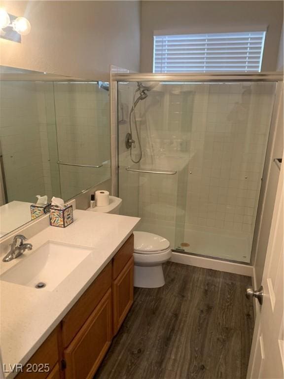 full bathroom with vanity, toilet, wood finished floors, and a stall shower