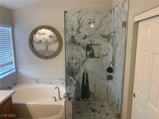 full bath featuring a marble finish shower, a bath, and vanity