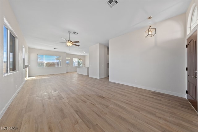 unfurnished living room with visible vents, light wood-style flooring, and baseboards