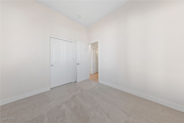 unfurnished bedroom with a closet, carpet flooring, and baseboards