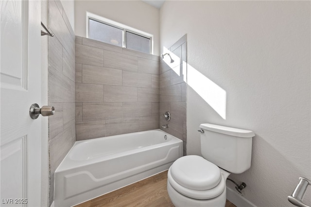 bathroom with shower / tub combination, wood finished floors, and toilet