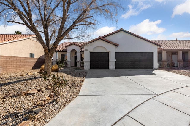 mediterranean / spanish-style home featuring a garage, brick siding, fence, concrete driveway, and stucco siding