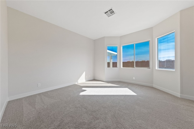 spare room featuring a wealth of natural light, visible vents, and carpet flooring