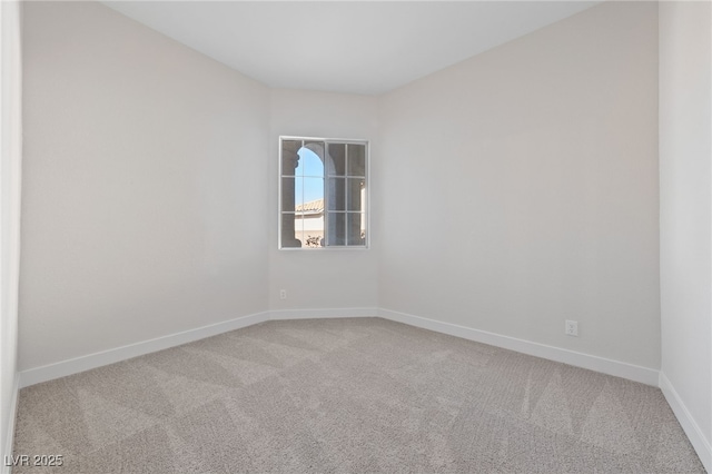 spare room featuring carpet and baseboards