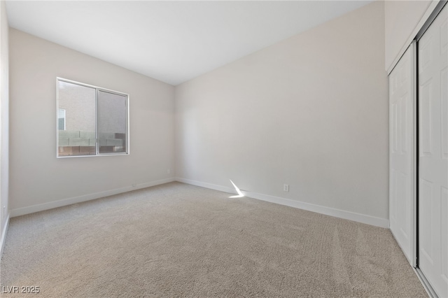 unfurnished bedroom featuring carpet floors, a closet, and baseboards