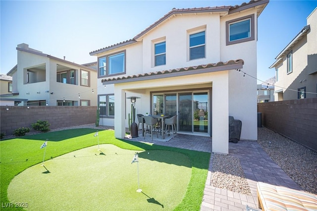 back of property with a patio area, a fenced backyard, a tile roof, and stucco siding