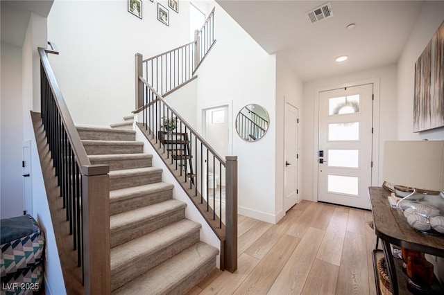 entrance foyer featuring recessed lighting, visible vents, light wood-style flooring, baseboards, and stairs