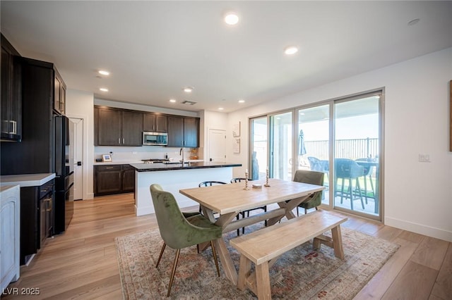 dining room with baseboards, light wood-type flooring, and recessed lighting