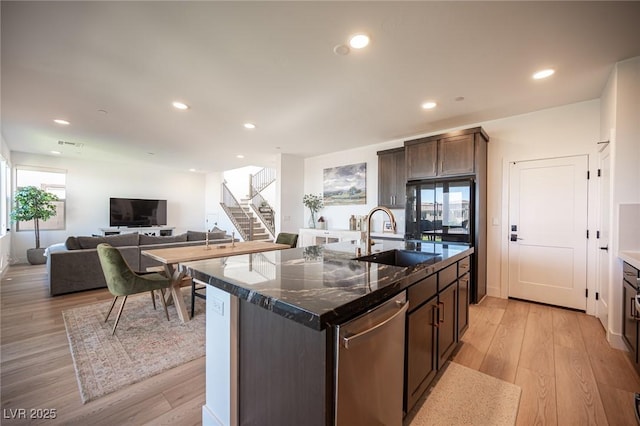 kitchen with dishwasher, light wood finished floors, a sink, and recessed lighting