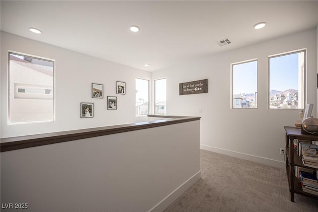 hall featuring carpet, visible vents, baseboards, and recessed lighting