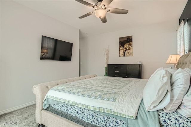 carpeted bedroom with ceiling fan and baseboards