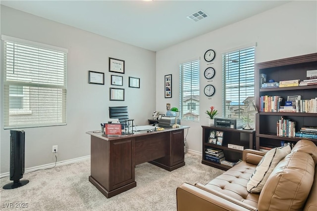 office space with visible vents, light carpet, and baseboards