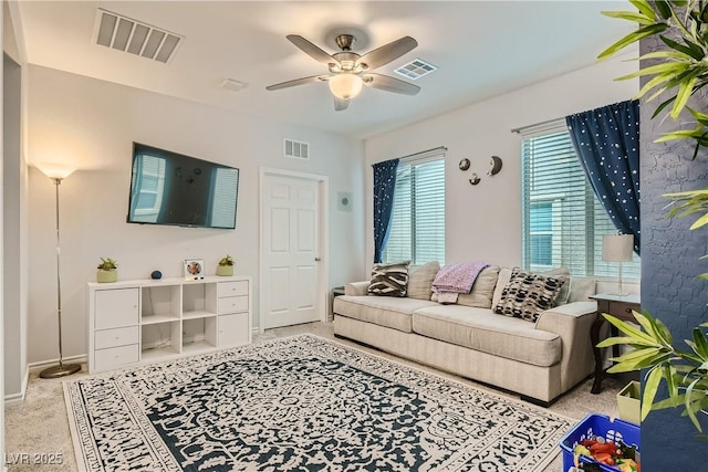 living room featuring a ceiling fan, light colored carpet, and visible vents