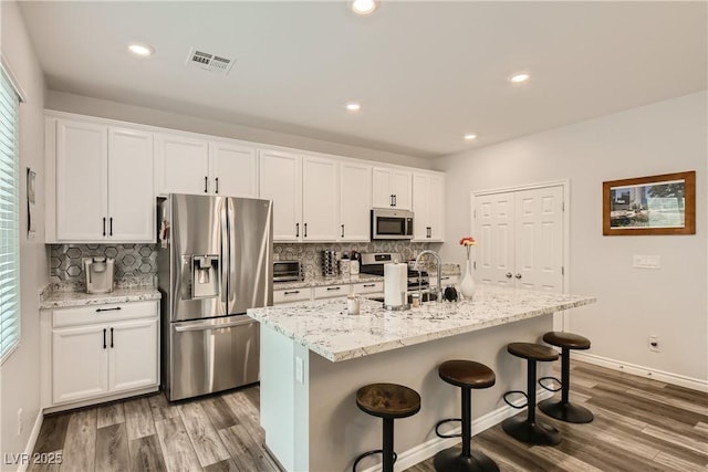 kitchen featuring white cabinetry, visible vents, appliances with stainless steel finishes, and a sink