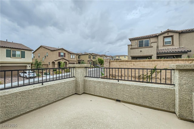 view of patio / terrace with a balcony, a residential view, and fence