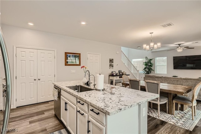 kitchen with dishwasher, a sink, visible vents, and dark wood-style floors