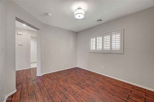 spare room featuring baseboards, visible vents, and hardwood / wood-style floors