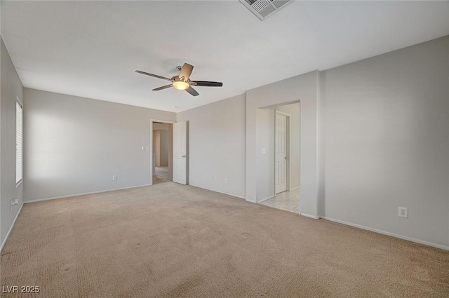 unfurnished room featuring ceiling fan, baseboards, visible vents, and light colored carpet