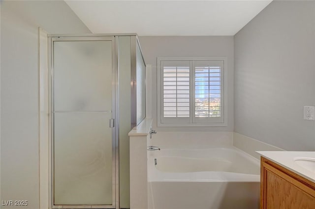 bathroom with a stall shower, a bath, and vanity