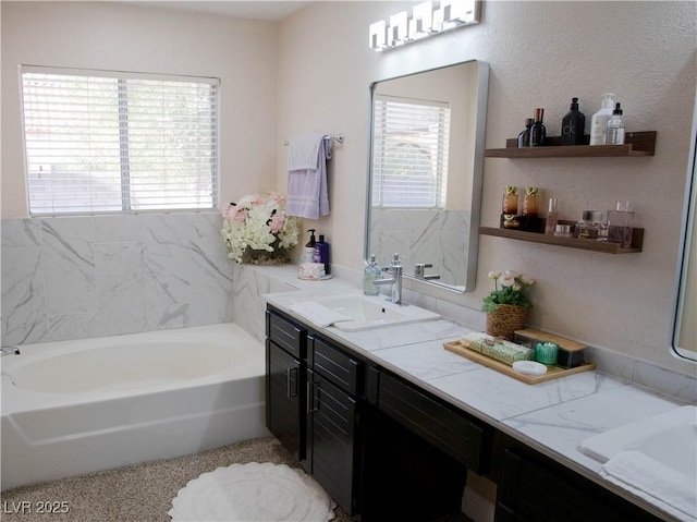 full bath with a garden tub, double vanity, and a sink