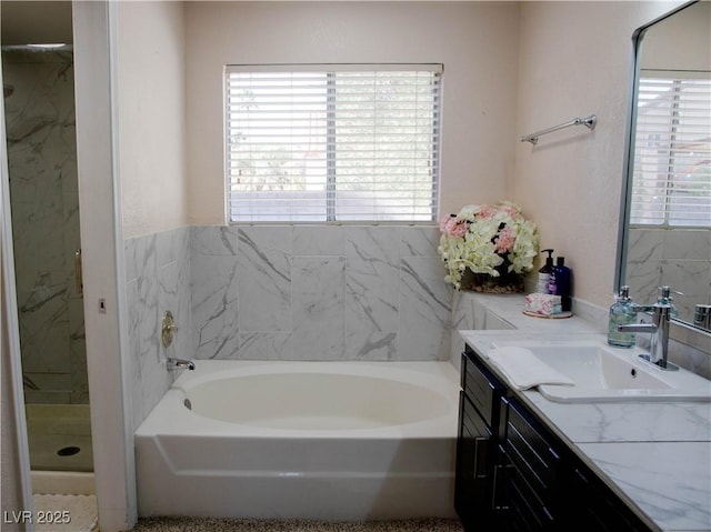 bathroom featuring a shower stall, a garden tub, plenty of natural light, and vanity