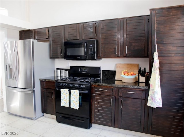 kitchen with black appliances, dark stone countertops, light tile patterned floors, and dark brown cabinets