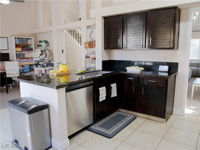 kitchen with light tile patterned floors, dishwasher, a peninsula, dark brown cabinets, and a sink