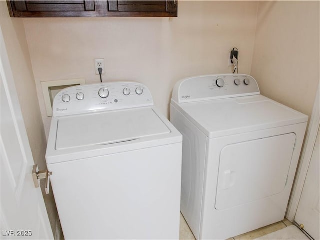 clothes washing area featuring cabinet space and separate washer and dryer