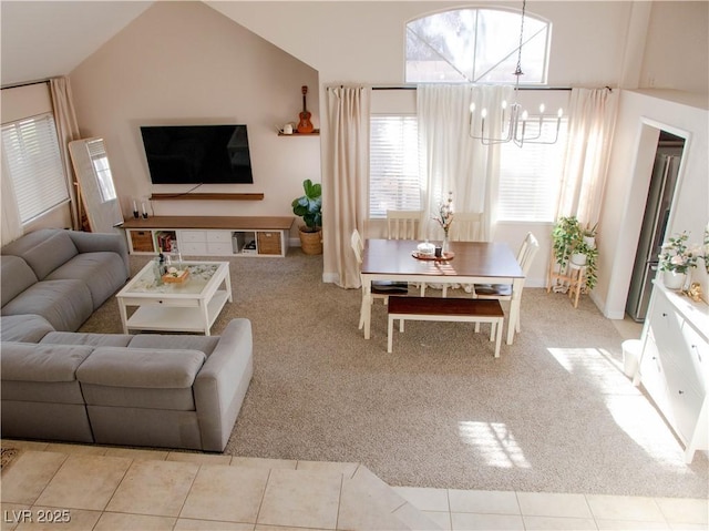 living room with carpet floors, tile patterned floors, vaulted ceiling, and an inviting chandelier