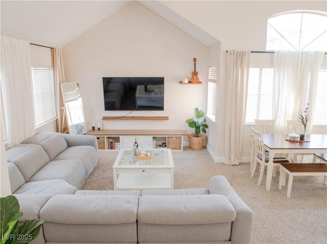 carpeted living area with vaulted ceiling and baseboards