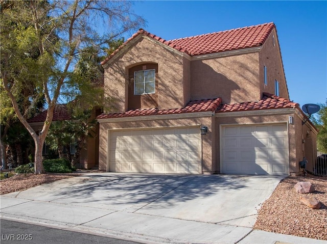 mediterranean / spanish-style home with a garage, concrete driveway, a tiled roof, and stucco siding