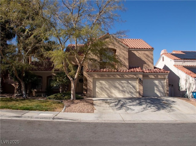 mediterranean / spanish-style home featuring a tiled roof, an attached garage, driveway, and stucco siding