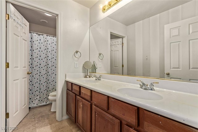 bathroom with a sink, double vanity, and toilet