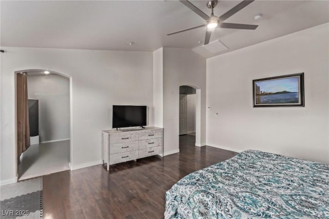 bedroom with vaulted ceiling, wood finished floors, baseboards, and arched walkways