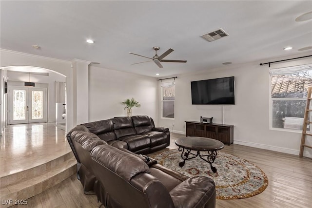 living room with a ceiling fan, visible vents, baseboards, arched walkways, and recessed lighting