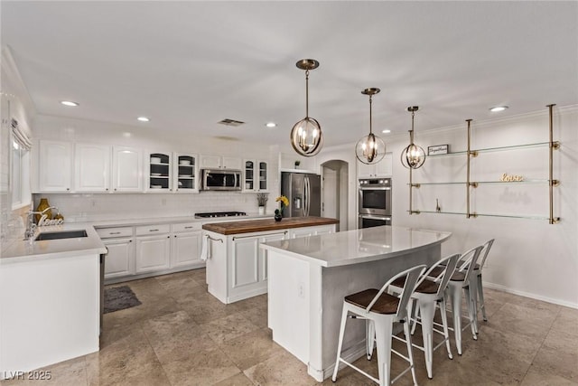 kitchen featuring recessed lighting, a center island, a sink, decorative backsplash, and stainless steel appliances