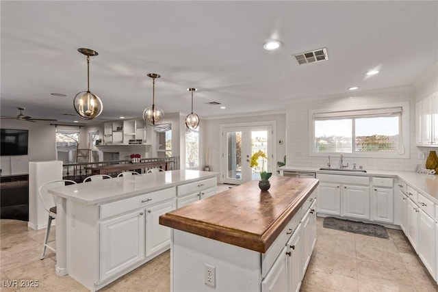 kitchen featuring a sink, visible vents, recessed lighting, decorative backsplash, and a center island