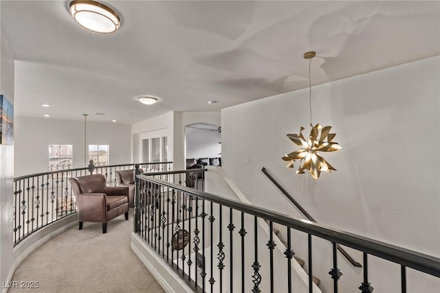hall featuring carpet and an upstairs landing